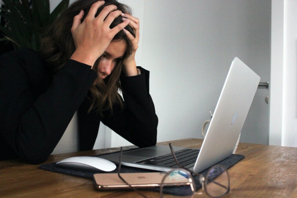 Frau schaut sehr gestresst in Laptop